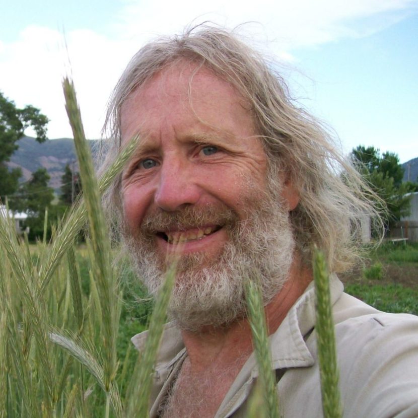 Joseph smiles while standing in a field of landrace rye grass.